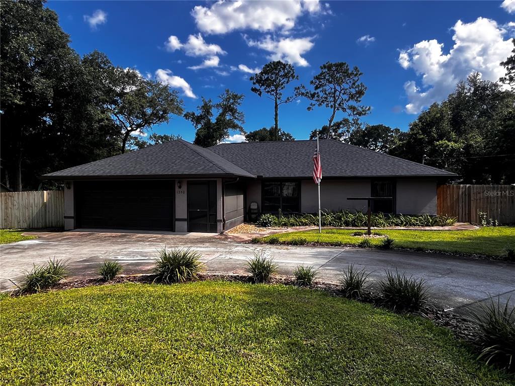 A single-story house with a dark roof, gray exterior, and a paved driveway — 1250 15TH STREET, ORANGE CITY, FL