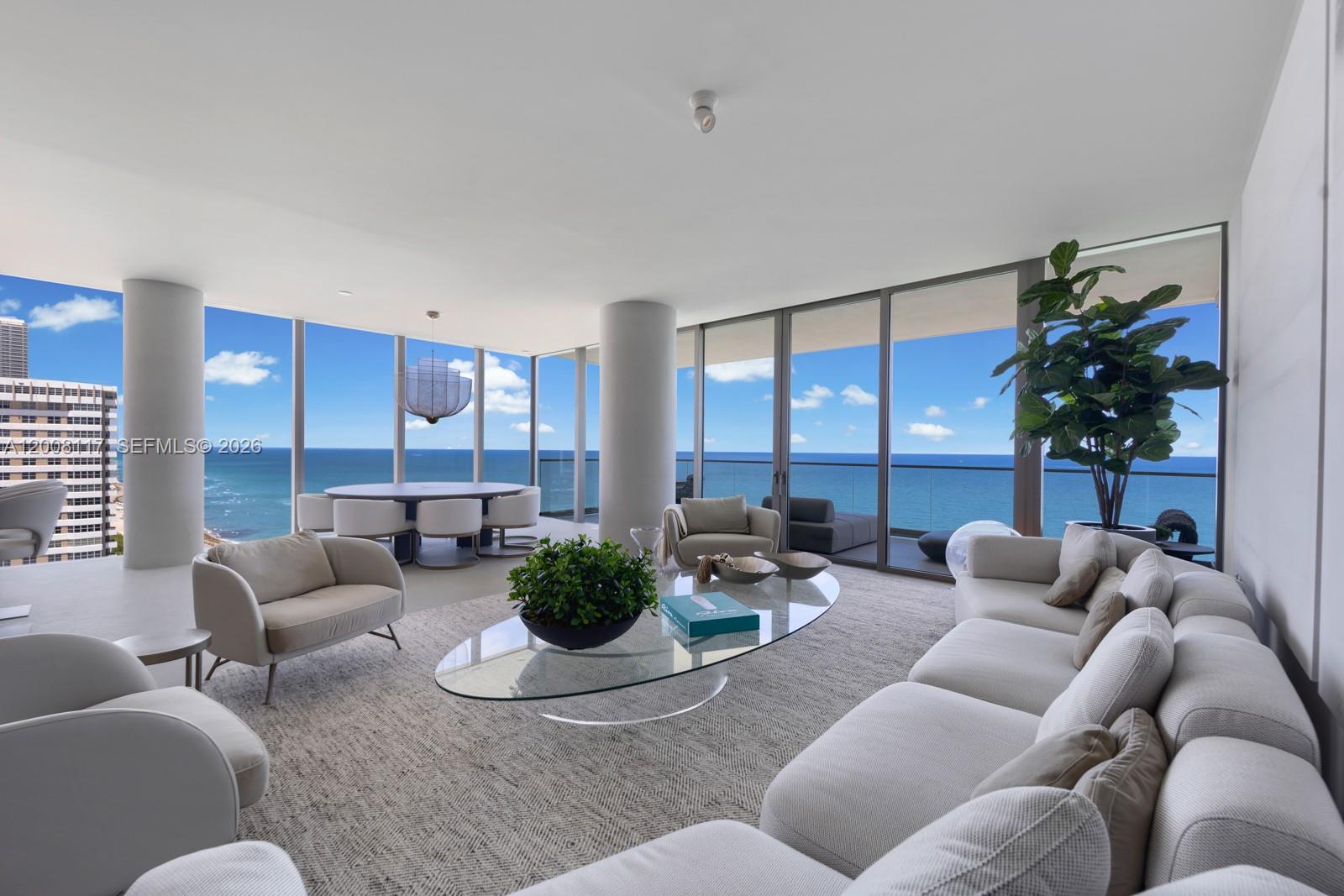 A modern living and dining area features floor-to-ceiling windows with expansive ocean views — 2000 S Ocean Dr # 17A, Hallandale Beach FL 33009, HALLANDALE BEACH, FL