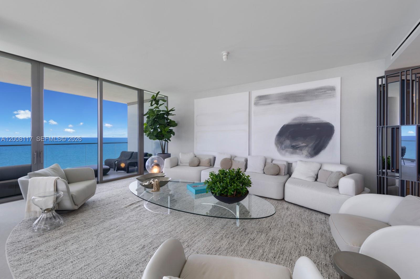 A modern living room features a large sectional sofa, glass coffee table, and ocean views — 2000 S Ocean Dr # 17A, Hallandale Beach FL 33009, HALLANDALE BEACH, FL