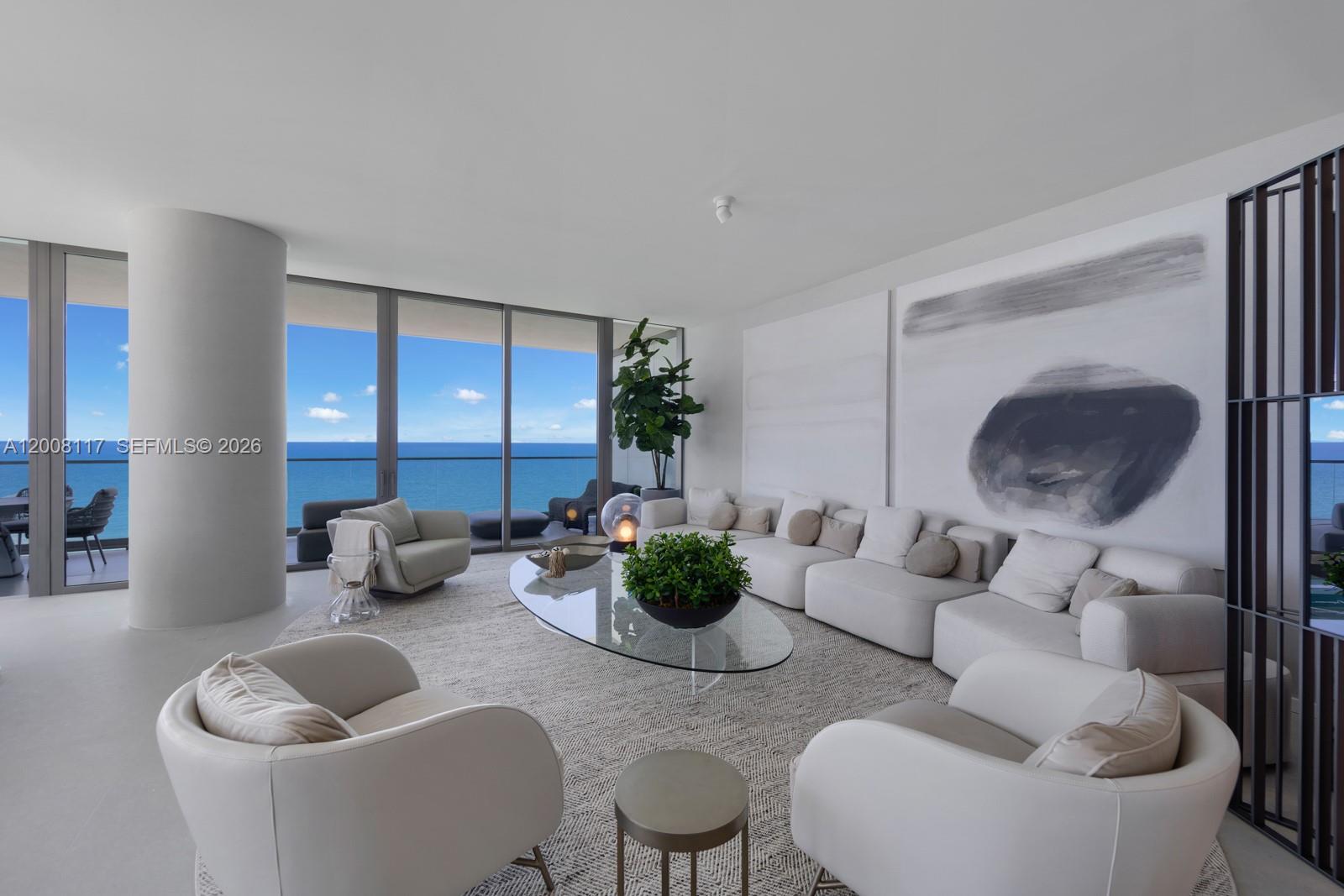 A modern living room features white furniture, a glass coffee table, and floor-to-ceiling ocean views — 2000 S Ocean Dr # 17A, Hallandale Beach FL 33009, HALLANDALE BEACH, FL