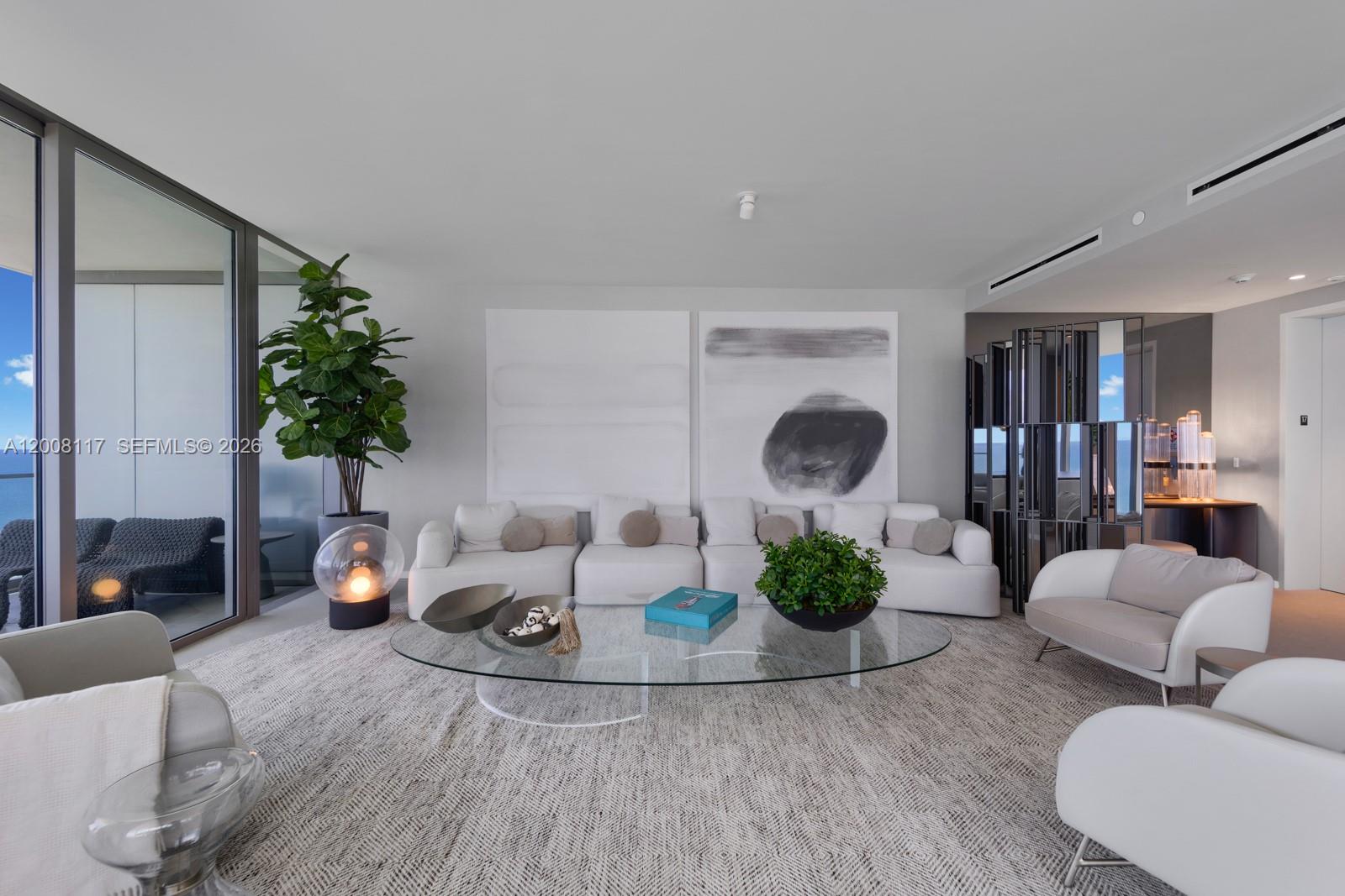 A modern living room features a white sectional sofa, glass coffee table, and large abstract art — 2000 S Ocean Dr # 17A, Hallandale Beach FL 33009, HALLANDALE BEACH, FL