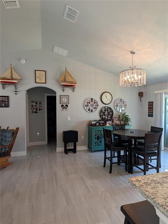 A dining area features a round table, chairs, a teal cabinet, and nautical wall decor — 5832 NW 63RD PLACE, OCALA, FL