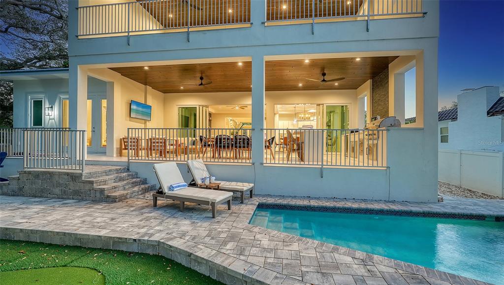 A two-story house exterior features a covered patio, swimming pool, and lounge chairs — 1537 SIESTA DRIVE, SARASOTA, FL