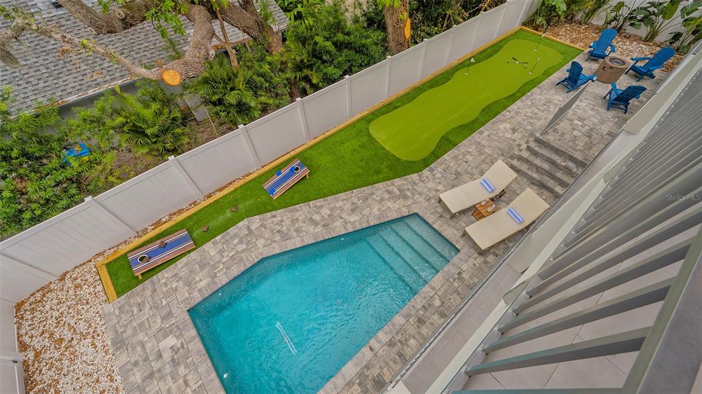 An aerial view of a backyard featuring a swimming pool, putting green, and lounge area — 1537 SIESTA DRIVE, SARASOTA, FL