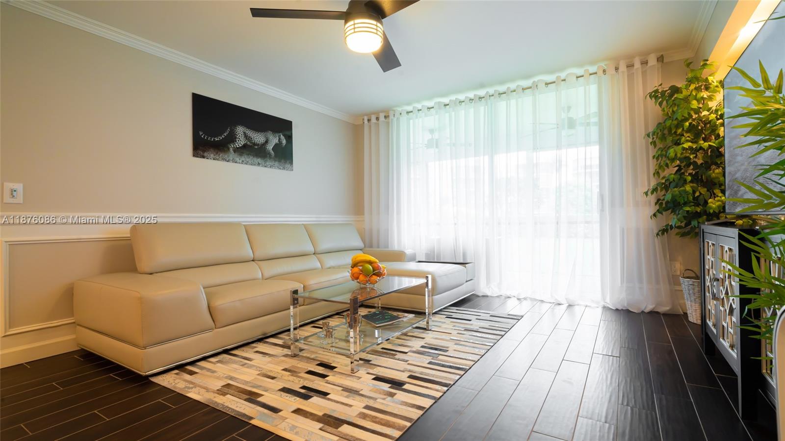 A living room features a beige leather sectional, glass coffee table, and dark wood flooring — 6500 NW 2nd Ave # 114, Boca Raton FL 33487, BOCA RATON, FL