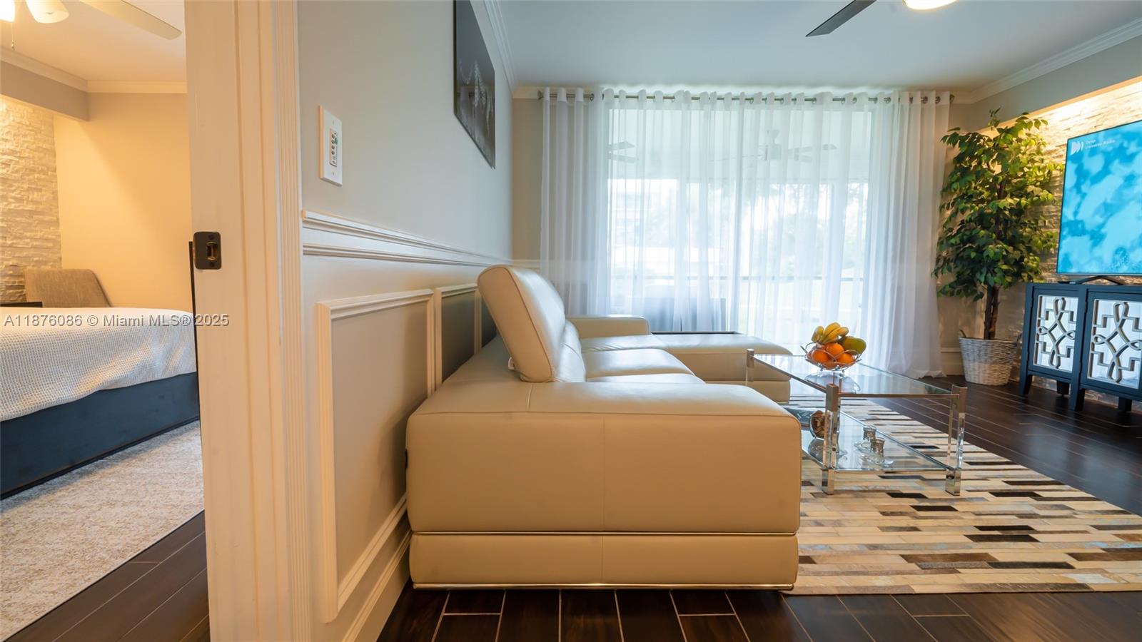 A living room features a white leather sectional, a glass coffee table, and dark flooring — 6500 NW 2nd Ave # 114, Boca Raton FL 33487, BOCA RATON, FL