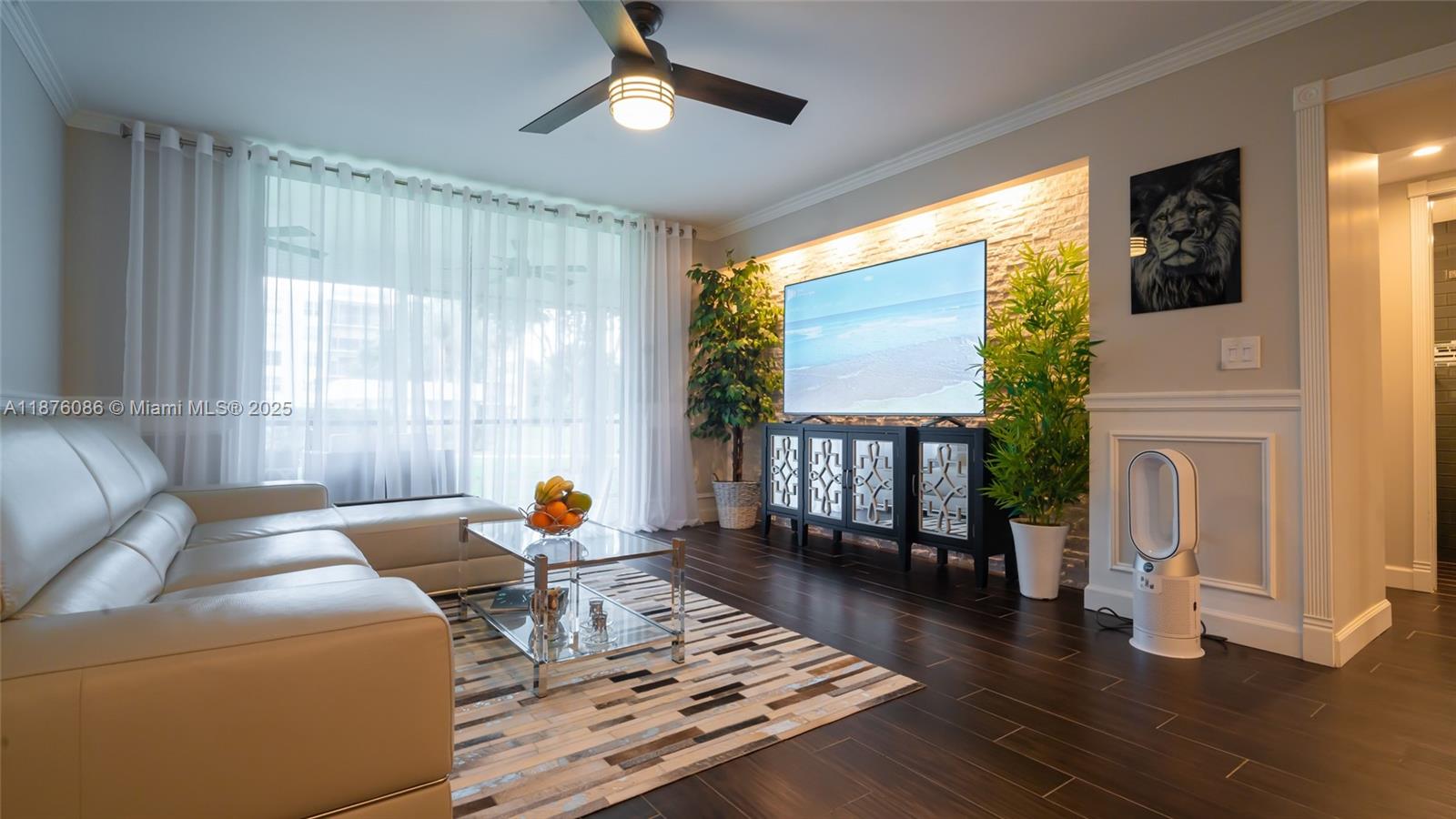 A living room features a white leather sofa, a stone accent wall, and dark flooring — 6500 NW 2nd Ave # 114, Boca Raton FL 33487, BOCA RATON, FL
