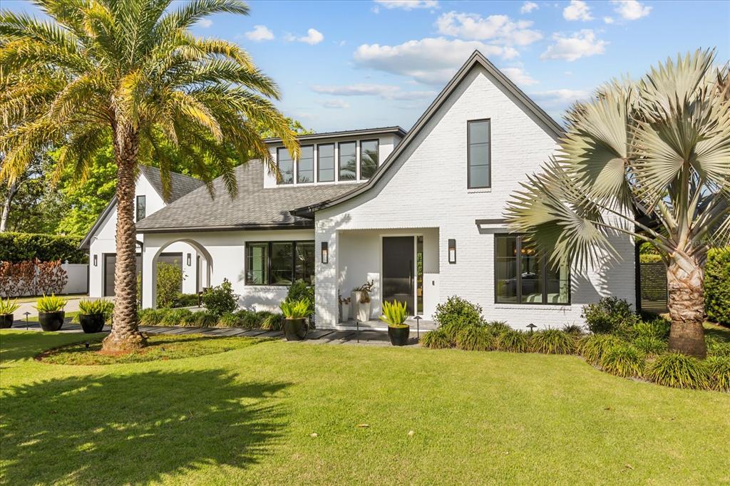 A white brick house with a dark roof and palm trees in the front yard — 1441 CARDINAL COURT, WINTER PARK, FL