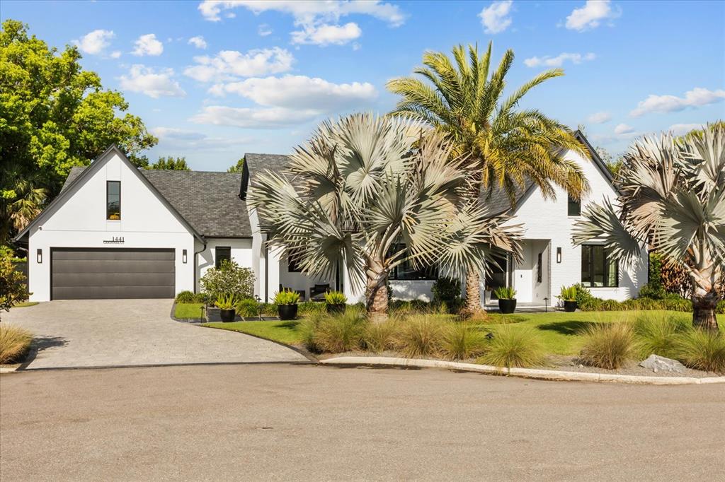 A white, single-story house with a dark roof, a two-car garage, and several palm trees — 1441 CARDINAL COURT, WINTER PARK, FL
