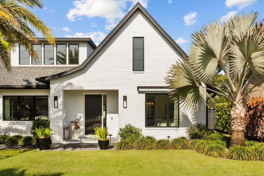 A white brick house with a dark roof, black window frames, and a front lawn — 1441 CARDINAL COURT, WINTER PARK, FL