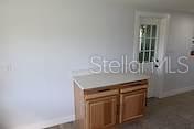 A kitchen corner features a built-in wooden bench seat, white cabinetry, and a window view — 559 NASTURTIUM AVENUE, SEBRING, FL