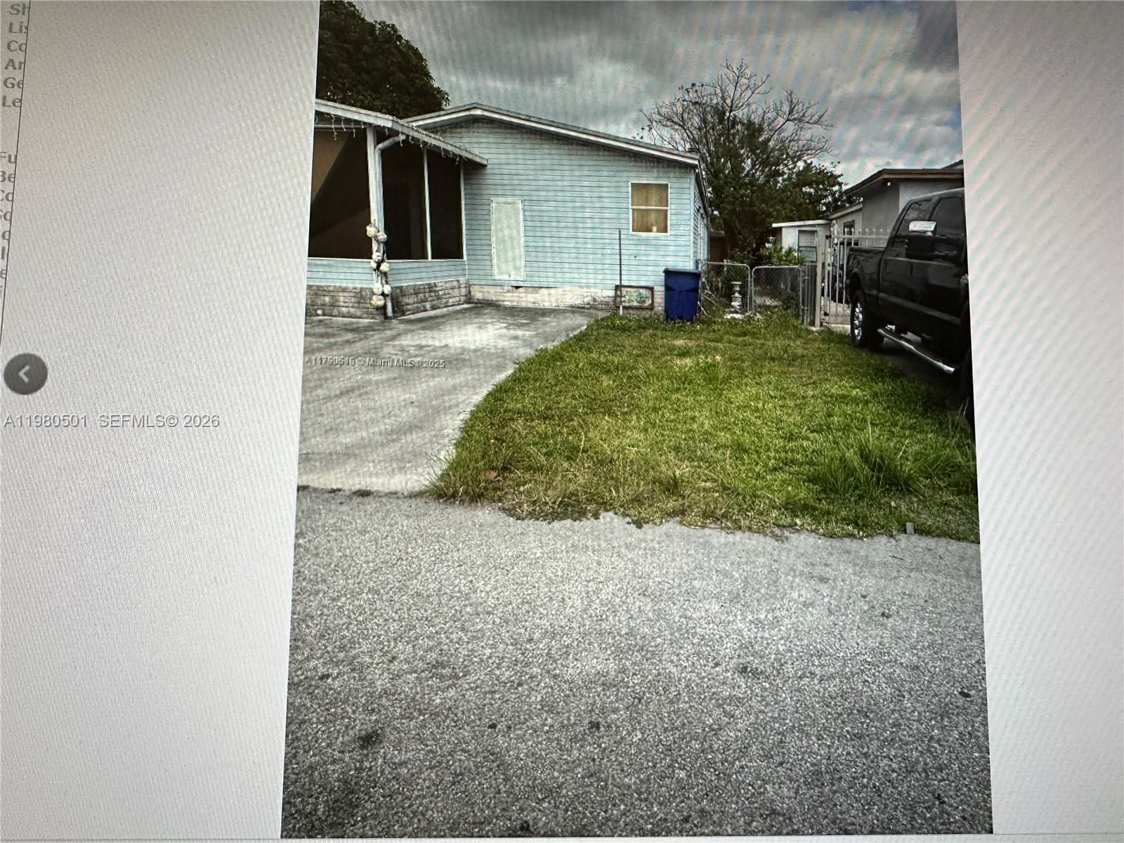 The exterior of a light blue manufactured home features a concrete driveway and small lawn — 19800 SW 180th Ave Lot 266, Miami FL 33187, MIAMI, FL