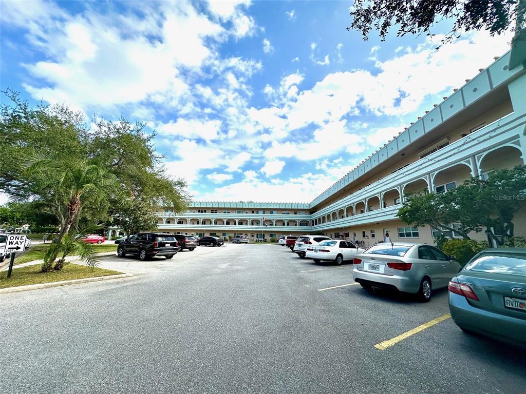 A multi-story apartment building with exterior walkways and a parking lot in the foreground — 2287 PHILIPPINE DRIVE UNIT 29, CLEARWATER, FL