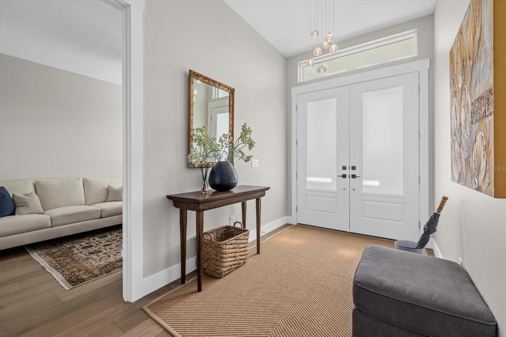 An entryway features a console table, a mirror, a bench, and double glass-paneled front doors — 8086 CLYDE CIRCLE, PORT CHARLOTTE, FL