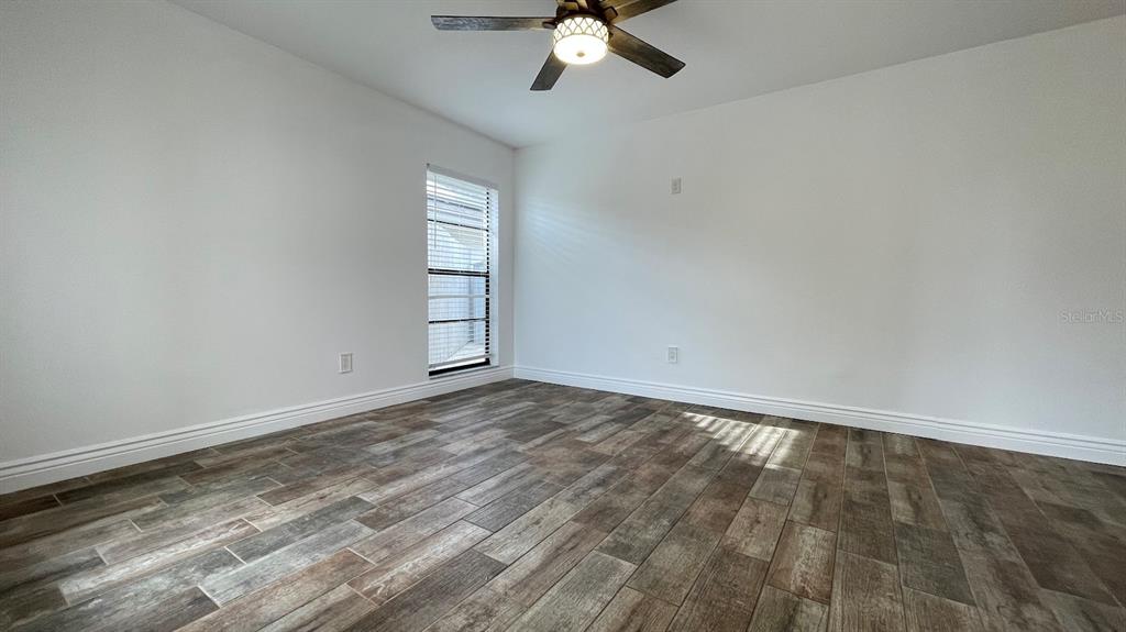 An empty bedroom features white walls, a ceiling fan, and wood-look tile flooring — 6181 SPRINGWATER STREET, ORLANDO, FL