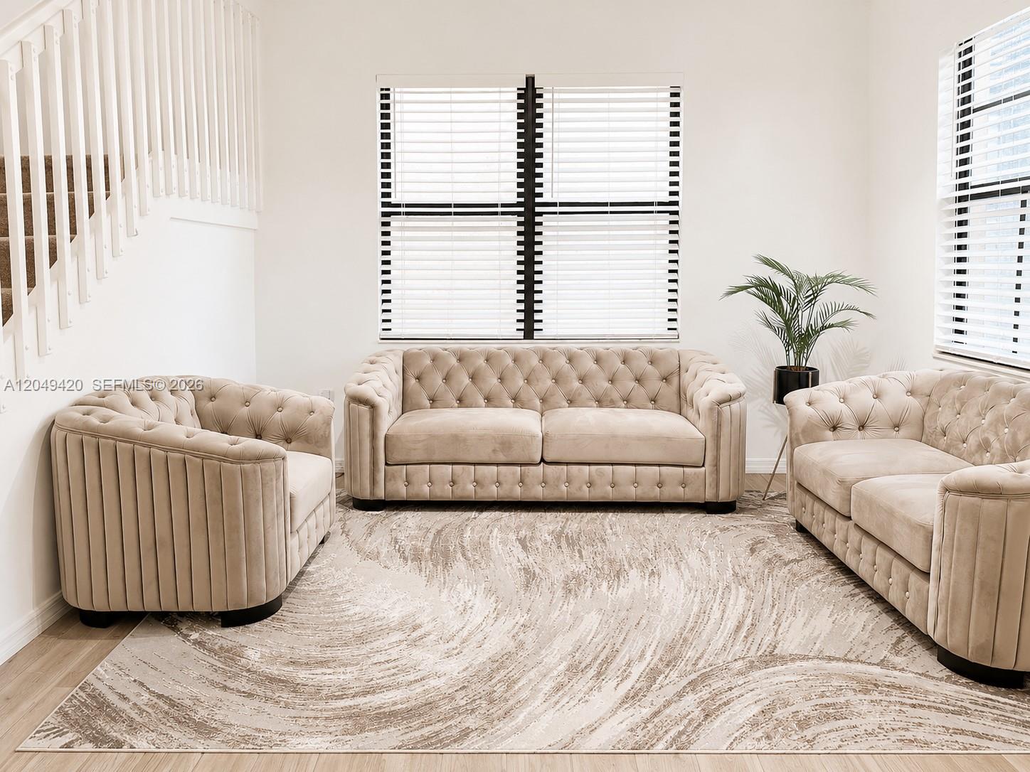 A living room features a beige tufted sofa set, a patterned area rug, and white blinds — 19316 NE 8th Ct, Miami FL 33179, MIAMI, FL