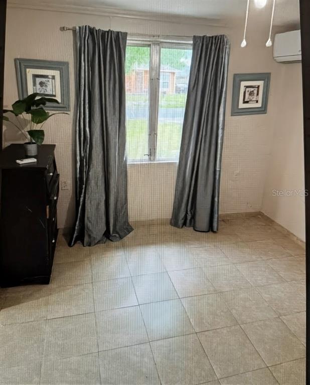 A room with tiled flooring, gray curtains, a black dresser, and two framed wall pictures — 2725 SAMPLE STREET, KISSIMMEE, FL