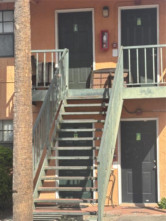 An exterior view of an apartment building with a metal staircase leading to two units — 12403 HIBISCUS OAK PLACE UNIT 202, TAMPA, FL
