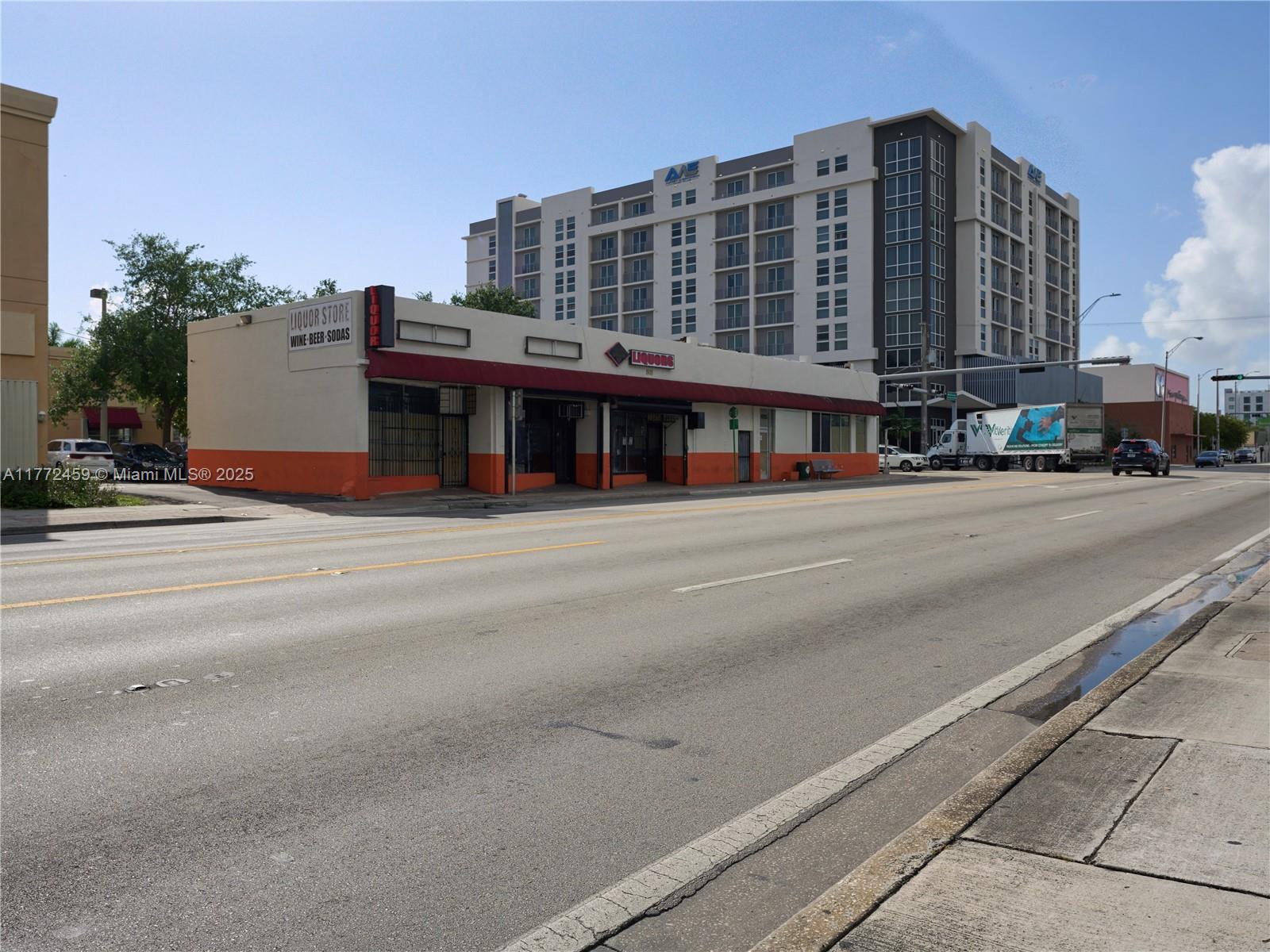 A single-story liquor store building stands beside a multi-story apartment complex along a street — 6211 NW 7th Ave # 663, Miami FL 33150, MIAMI, FL