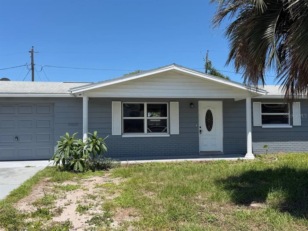A single-story gray house with a white front door, shutters, and a small front lawn — 3511 CAMBRIDGE STREET, NEW PORT RICHEY, FL