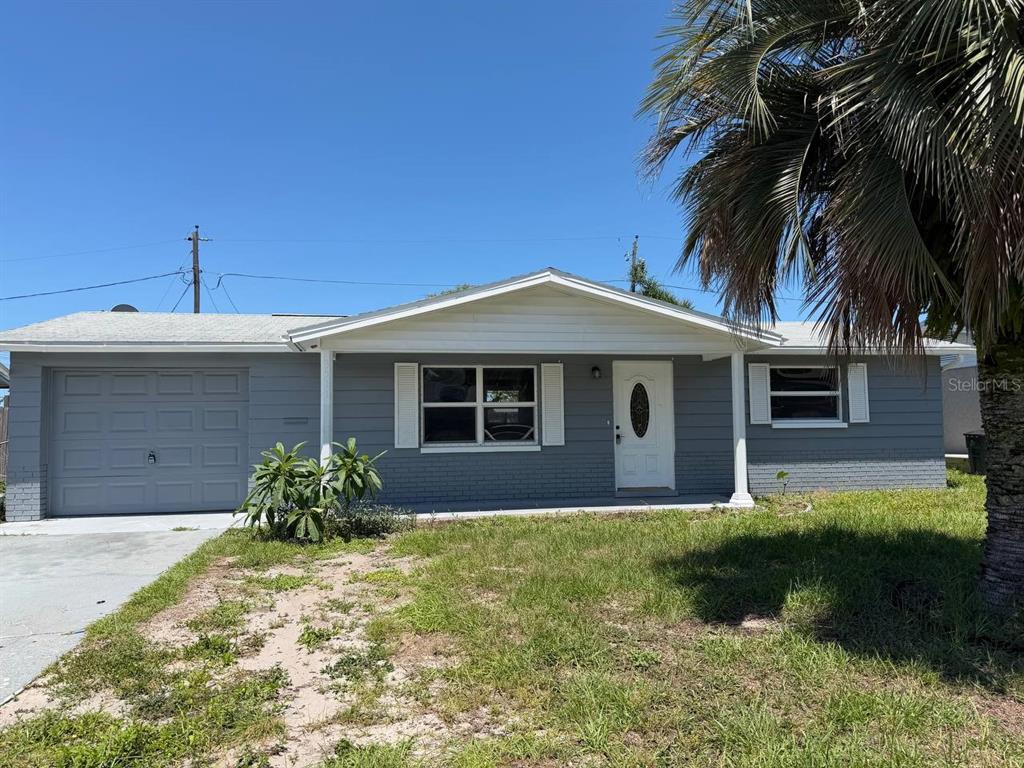 A single-story gray house with a garage, white trim, and a palm tree in front — 3511 CAMBRIDGE STREET, NEW PORT RICHEY, FL