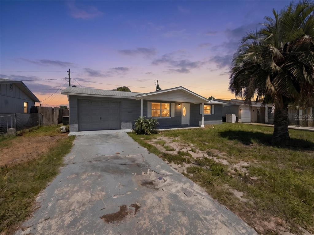 A single-story gray house with a garage and a palm tree in the front yard — 3511 CAMBRIDGE STREET, NEW PORT RICHEY, FL