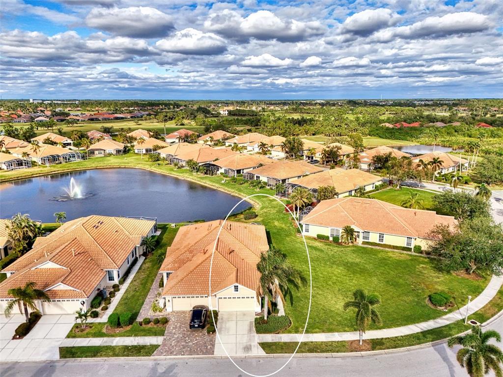An aerial view shows a residential house with a tile roof and driveway — 4980 WHISPERING OAKS DRIVE, NORTH PORT, FL