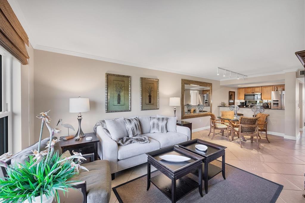 A living room with a sofa, two coffee tables, and an adjacent dining area — 8750 MIDNIGHT PASS ROAD UNIT 302, SARASOTA, FL