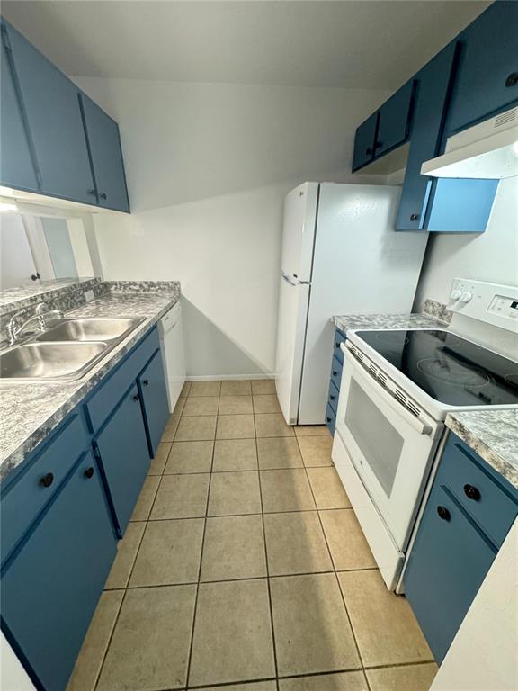 A galley kitchen features blue cabinets, white appliances, and a gray speckled countertop — 4000 SW 23RD STREET UNIT 1-106, GAINESVILLE, FL
