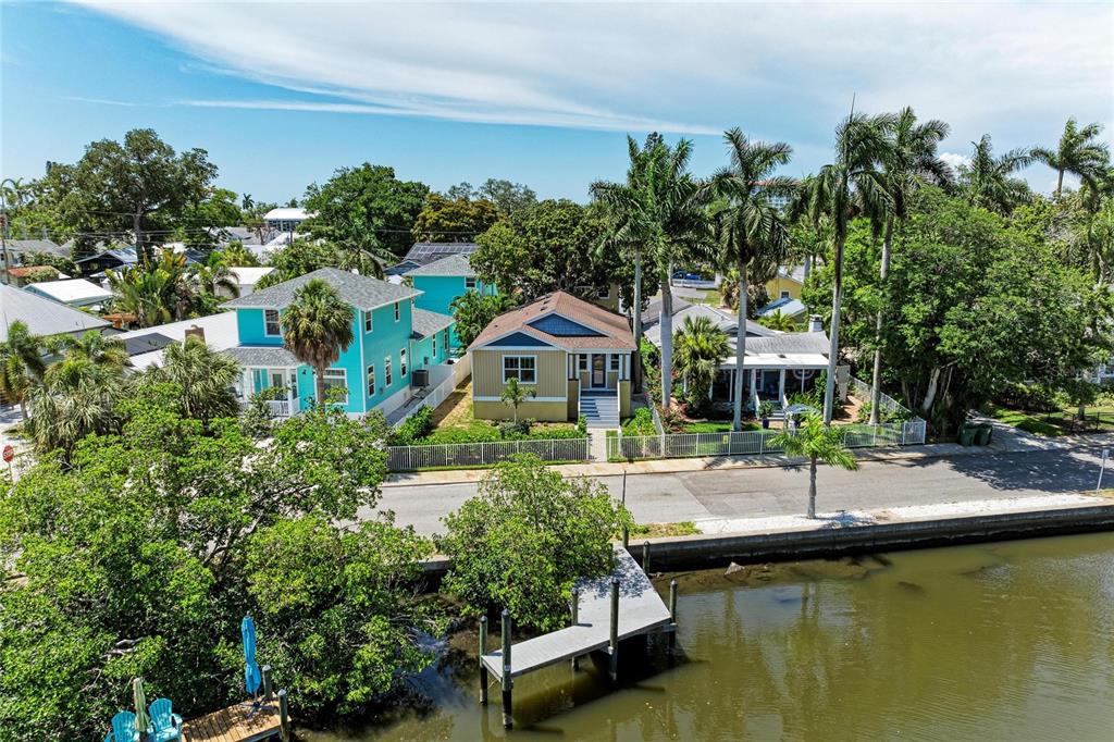 An aerial view shows three houses along a canal with a private wooden dock — 632 VIRGINIA DRIVE, BRADENTON, FL
