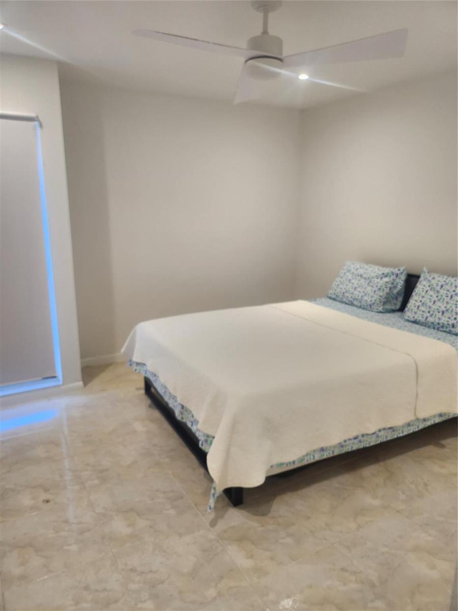 A bedroom features light-colored tile flooring, a ceiling fan, and a bed with patterned pillows — 4160 Inverrary Drive # 311, Lauderhill FL 33319, LAUDERHILL, FL