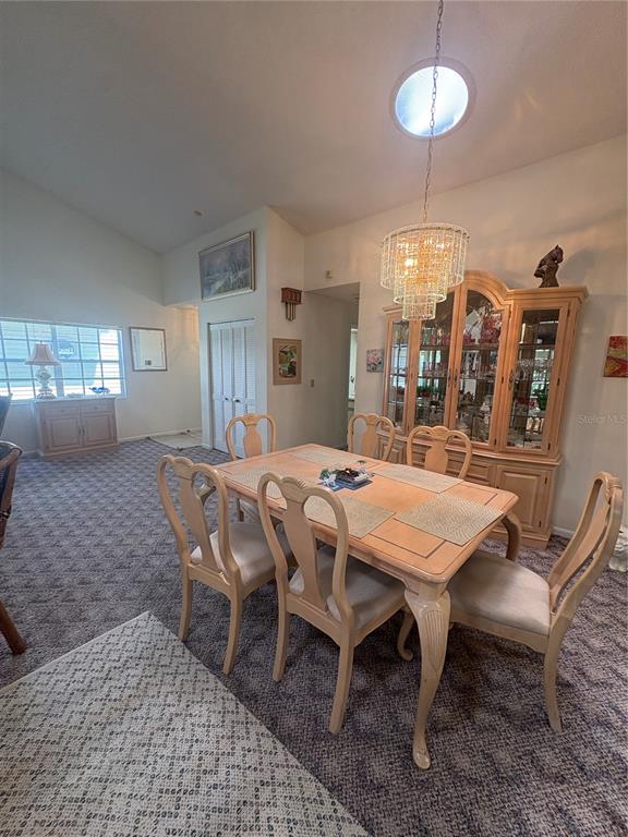 A dining room features a wooden table, six chairs, a china cabinet, and carpeted floors — 22 BRISTOL DRIVE, PALM COAST, FL