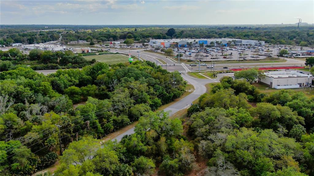 An aerial view shows a wooded lot adjacent to a road and a large shopping center — 9236-9248,9234 OLD GIBSONTON DRIVE, GIBSONTON, FL