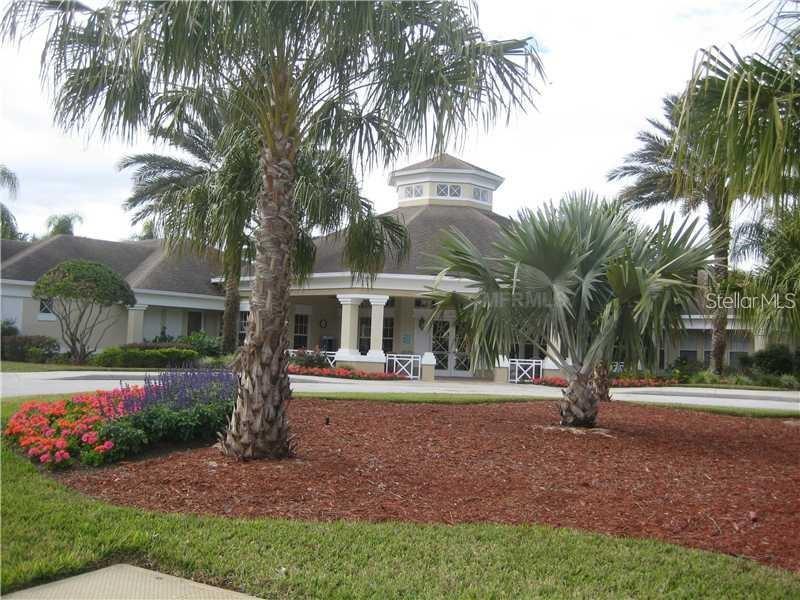 A single-story building with a cupola, palm trees, and a landscaped garden in the foreground — 2411 SILVER PALM DRIVE, KISSIMMEE, FL