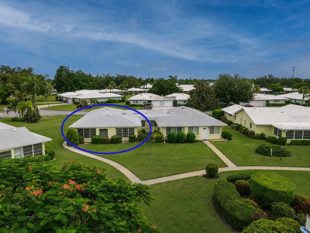 An aerial view of a light-colored single-story villa with a hip roof and landscaping — 7011 10TH AVENUE W, BRADENTON, FL