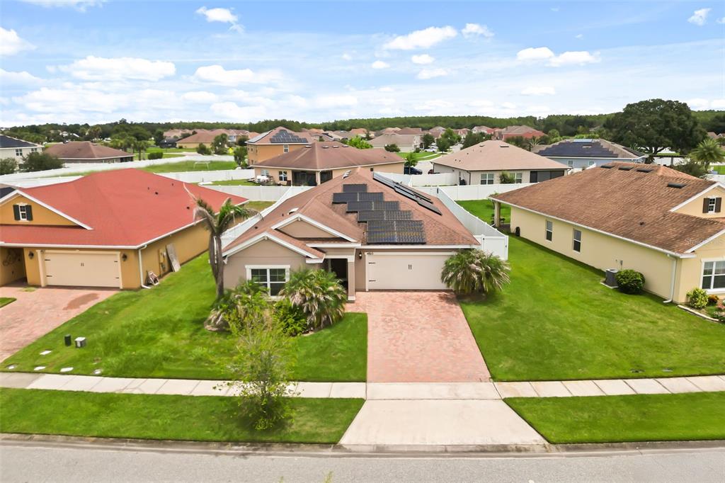 An aerial view of a suburban house with solar panels on the roof and a driveway — 4815 LAKE SHEPPARD STREET, KISSIMMEE, FL