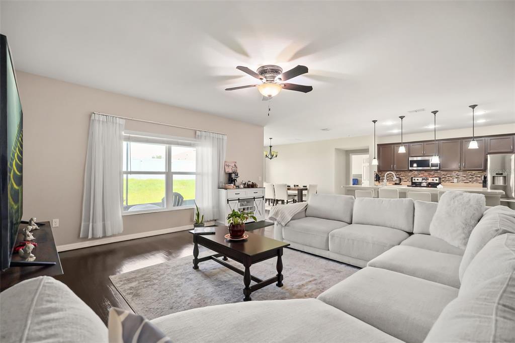 A living room with a sectional sofa, coffee table, and an open kitchen with island — 4815 LAKE SHEPPARD STREET, KISSIMMEE, FL