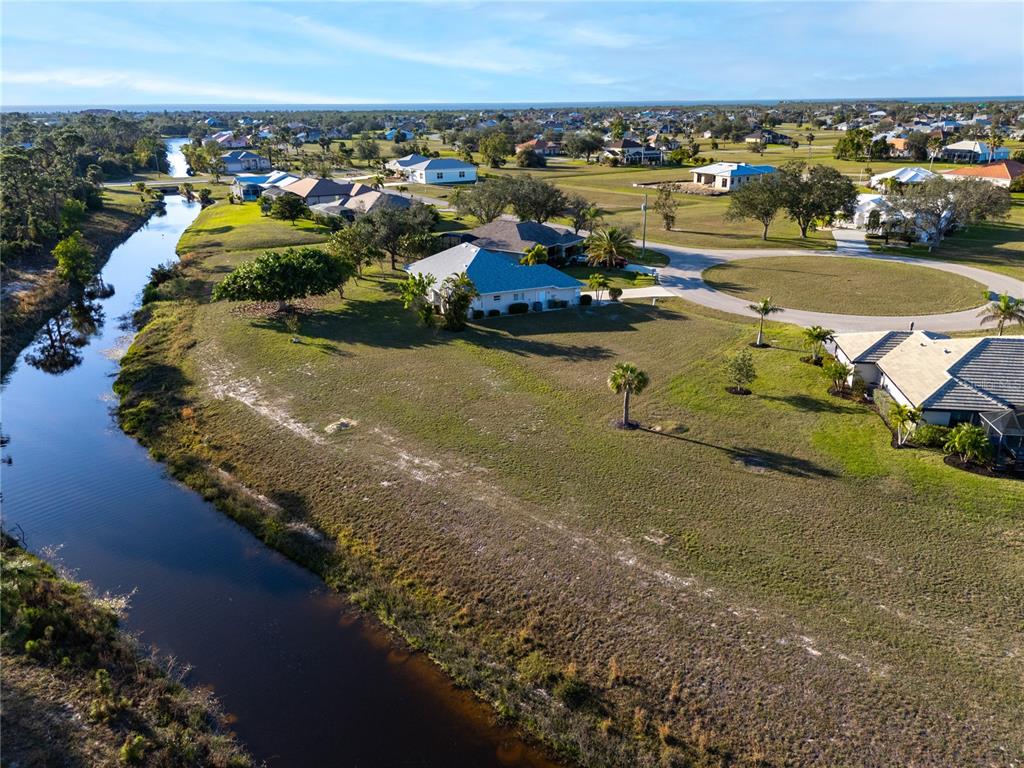 An aerial view shows a suburban neighborhood with houses situated along a canal — 24351 PENHOLLOW COURT, PUNTA GORDA, FL