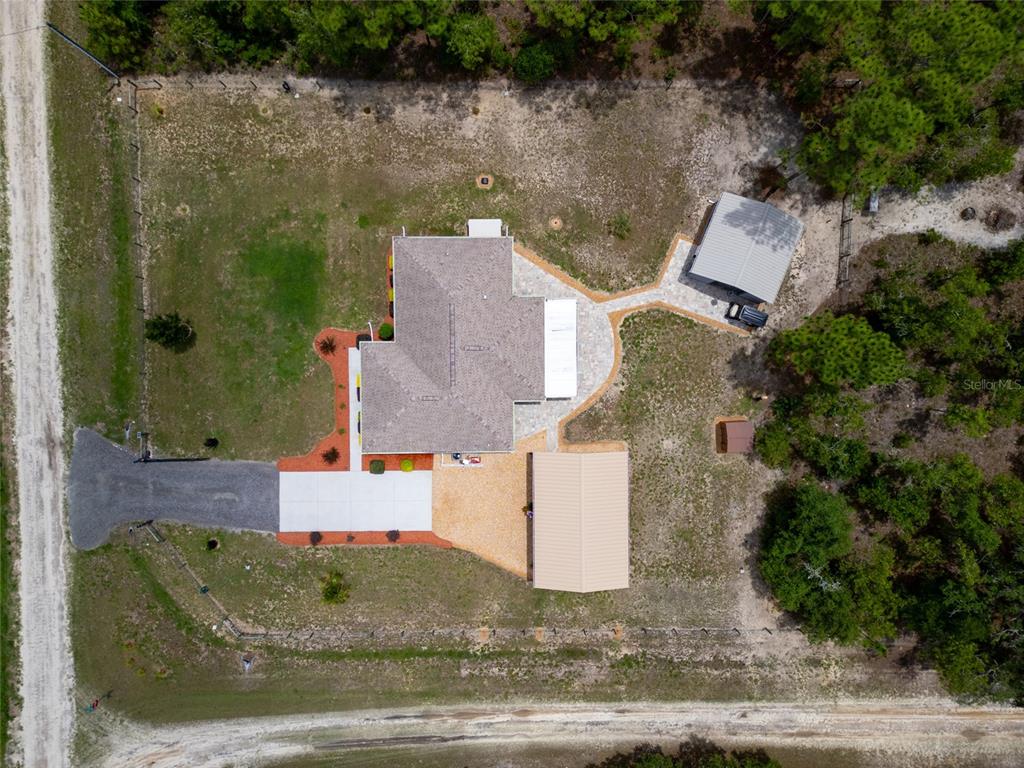 An aerial view shows a house with a driveway, two detached structures, and surrounding trees — 12368 SW 81ST STREET, DUNNELLON, FL