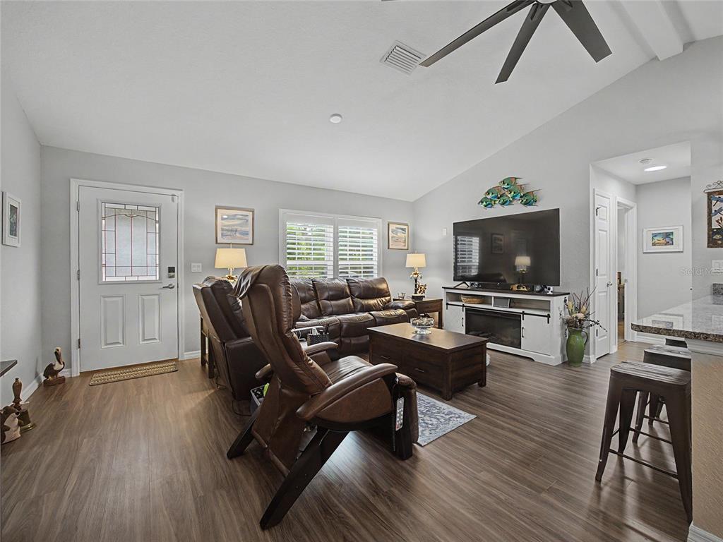 A living room features wood-look flooring, a leather sofa set, and a television console — 12368 SW 81ST STREET, DUNNELLON, FL