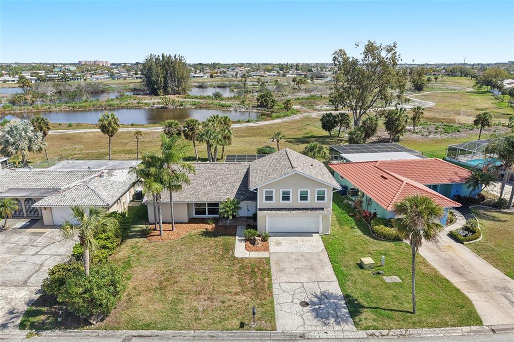 An aerial view shows a tan house with a two-car garage and a paved driveway — 3855 TOPSAIL TRAIL, NEW PORT RICHEY, FL