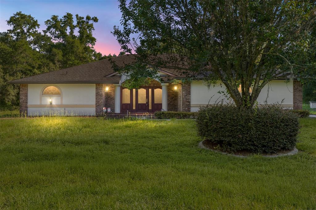 A single-story house with a brick entryway and a large tree in the front yard — 2657 W HAMPSHIRE STREET, INVERNESS, FL