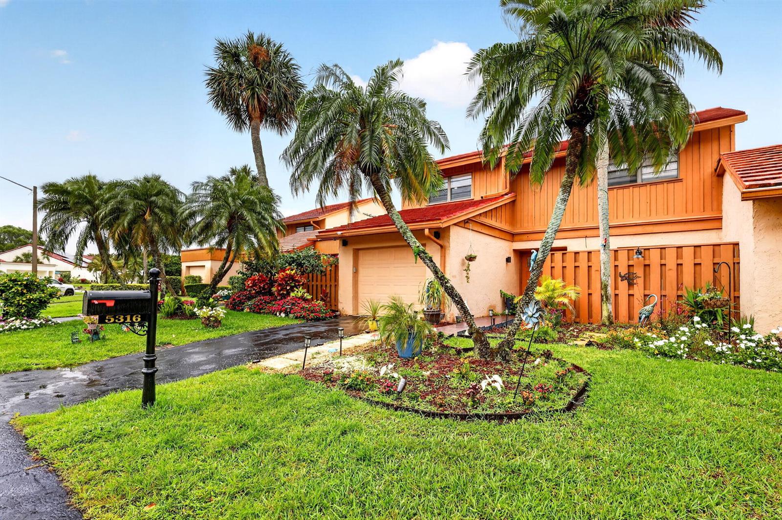 A two-story house with orange siding, a tile roof, and palm trees in the front yard — 5316 Stonybrook Lane, Boynton Beach FL 33437, BOYNTON BEACH, FL