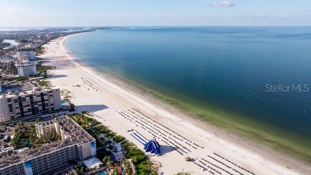 An aerial view of a sandy beach with high-rise buildings and a blue water slide — 5555 GULF BOULEVARD UNIT 312, ST PETERSBURG, FL