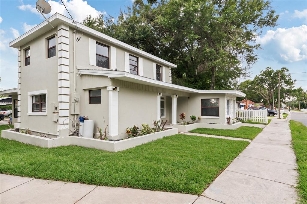 A two-story house with light-colored stucco walls, white trim, and a front lawn — 1325 E LAURA STREET, PLANT CITY, FL