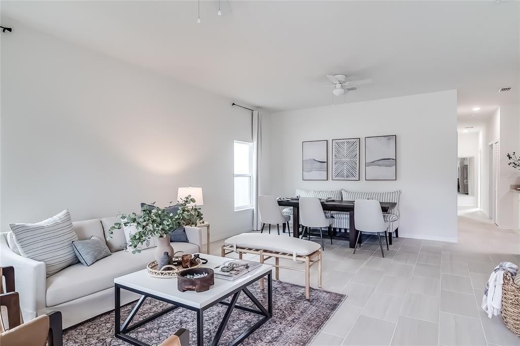 A bright living and dining area features a white sofa, coffee table, and dining set — 1103 Gigon Court, Sebring FL 33870, SEBRING, FL