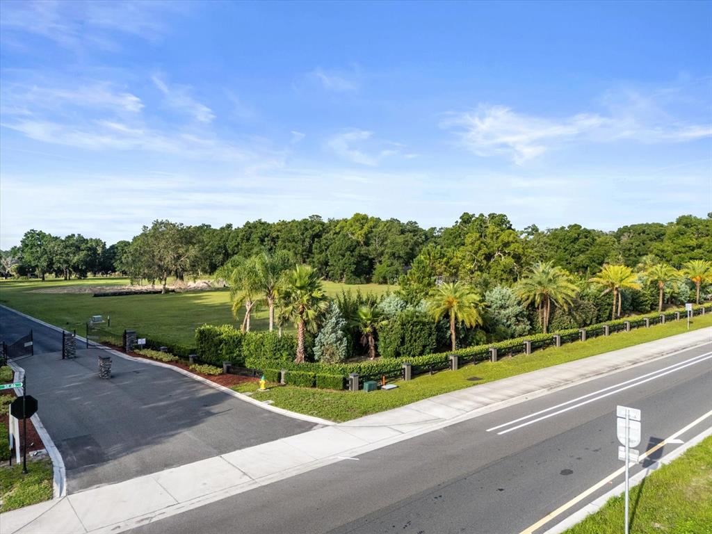 An aerial view shows a gated entrance leading to a large, grassy lot with trees — 314 GRAVINA POINT, SANFORD, FL