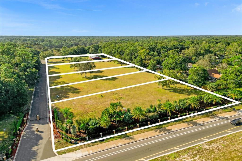 An aerial view shows a large, rectangular plot of land outlined in white near a road — 314 GRAVINA POINT, SANFORD, FL