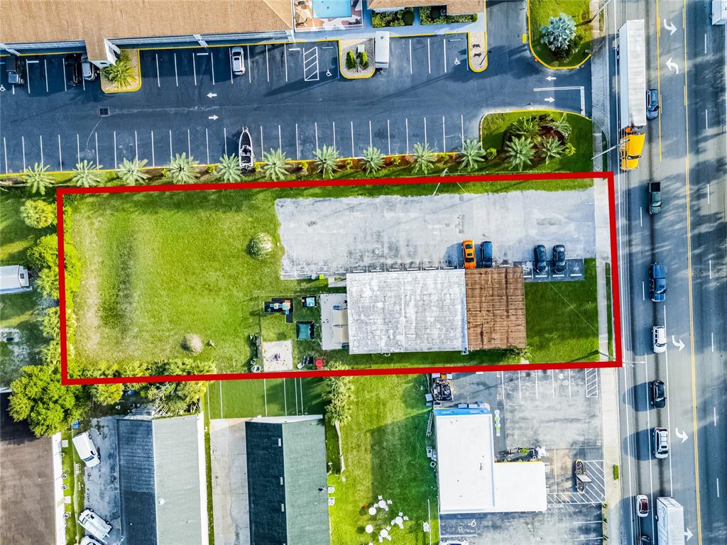 An aerial view shows a rectangular lot with a building, parking area, and grassy space — 465 S VOLUSIA AVENUE, ORANGE CITY, FL