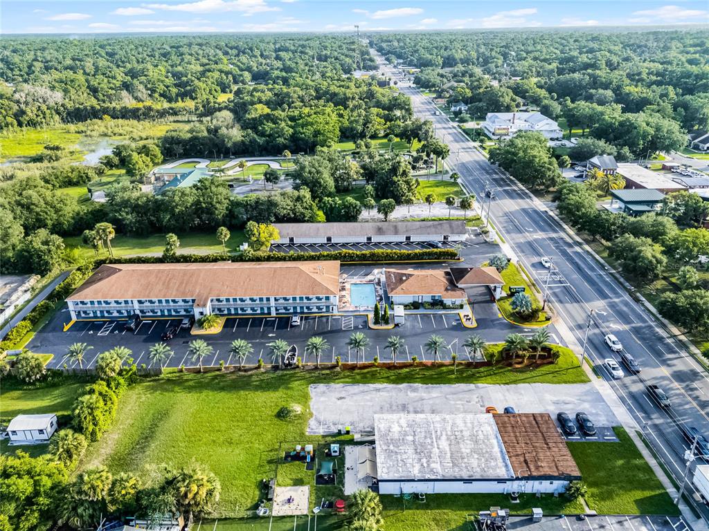 An aerial view shows a hotel with a pool, parking lot, and surrounding green space — 465 S VOLUSIA AVENUE, ORANGE CITY, FL